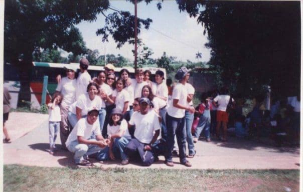 Un grupo de monitores de Comatillo en camiseta blanca, frente al autobús del campamento